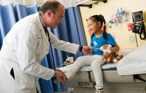 ένας γιατρός εξετάζει ένα παιδί με αρθροπάθεια ισχίου